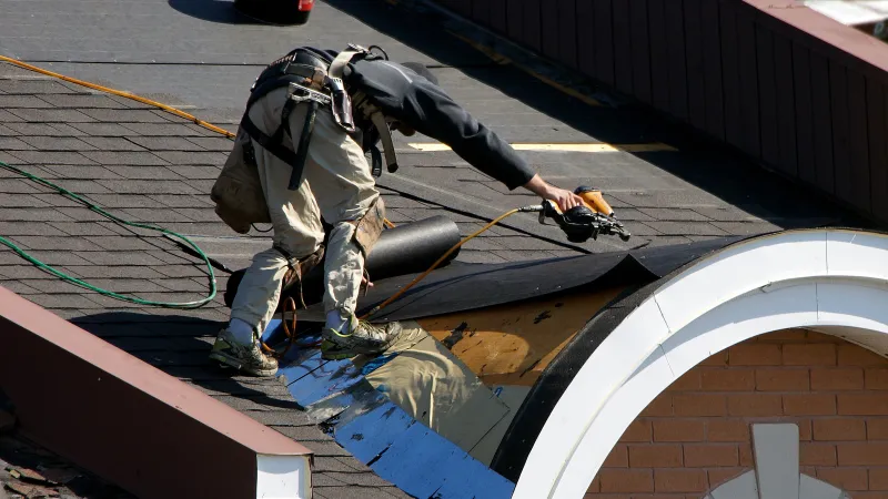 a man working on the side of a building