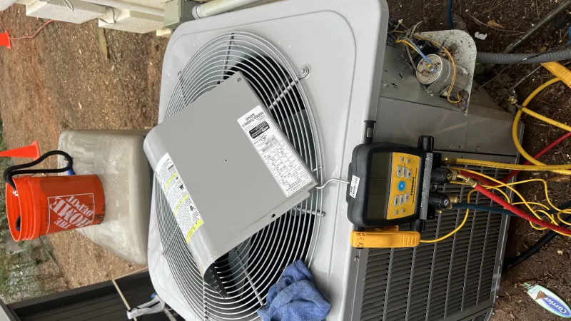 Outdoor HVAC unit undergoing maintenance with diagnostic tools, pressure gauges, and an orange Home Depot bucket.