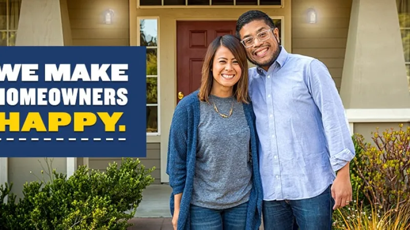 a man and woman standing in front of a building, two happy homeowners