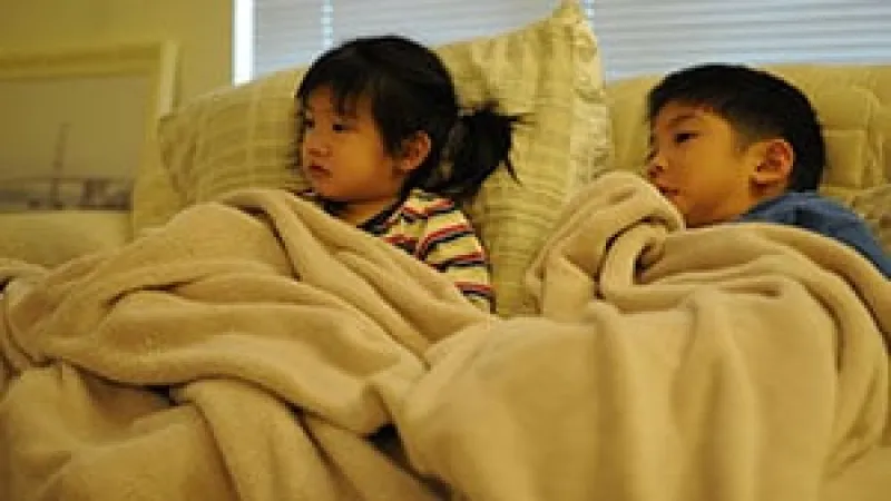 a couple of children lying on a bed