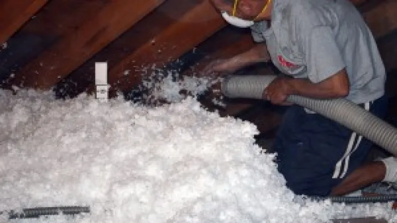 a man using insulating an attic