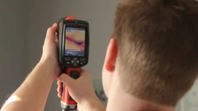 a man holding a heat scanner