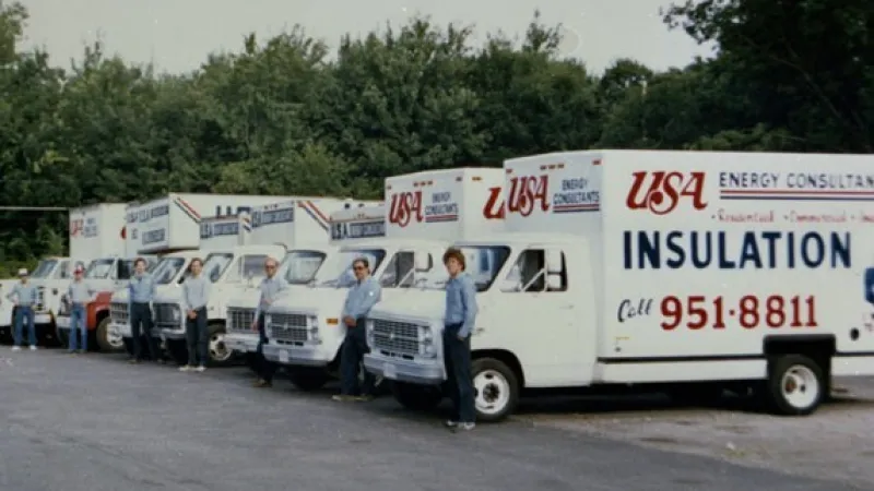 a group of USA Insulation vans parked together