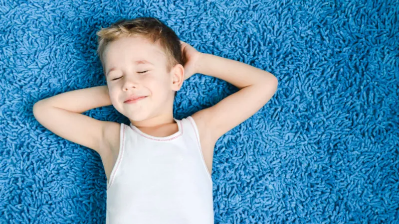 a boy lying on a blue surface