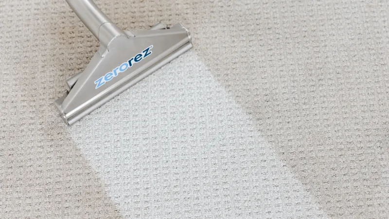 close up a Zerorez Zr Wand cleaning a gray carpet, showing a white stripe where its high alkaline Zr Water cleaned a stripe of the carpet clean