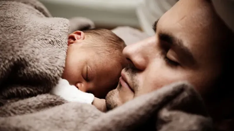 a man and a baby sleeping