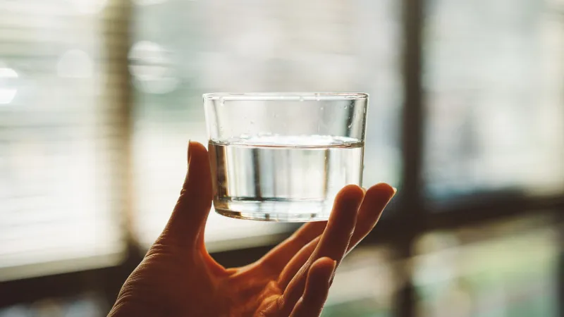 a hand holding a glass of water