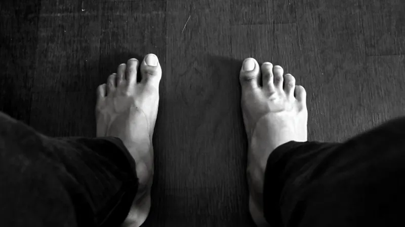 a pair of black feet on a wooden floor surface | Photo by Srinivas Reddy on Unsplash