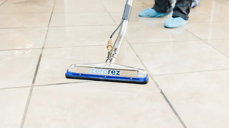 a Zerorez technician using a Zerorez® Zr™ Wand to clean a porcelain tile floor