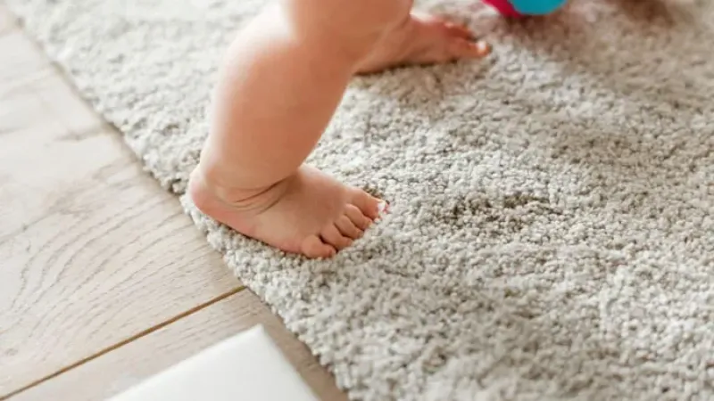 a baby's foot on a carpet