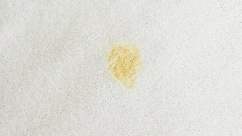 a yellow stain on a white carpet