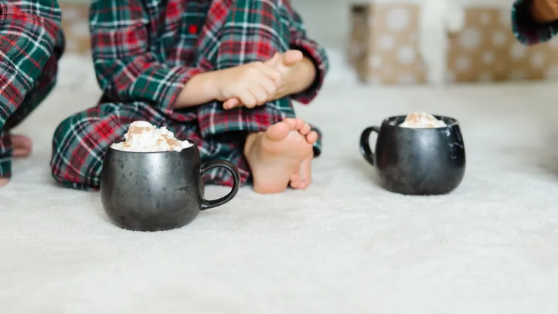 a child sitting at a table with a cup and saucer