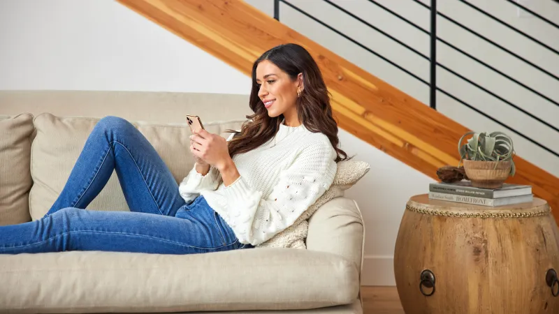 a woman sitting on a couch in a wool sweater