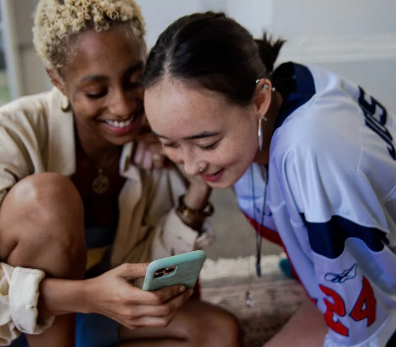 a woman showing a man something on the phone