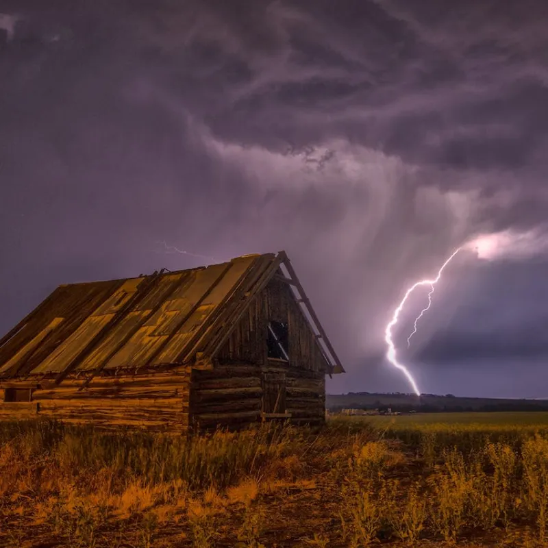 a house in a field in a storm