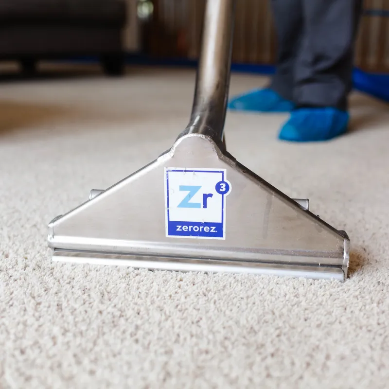 a Zerorez employee vacuuming a carpet