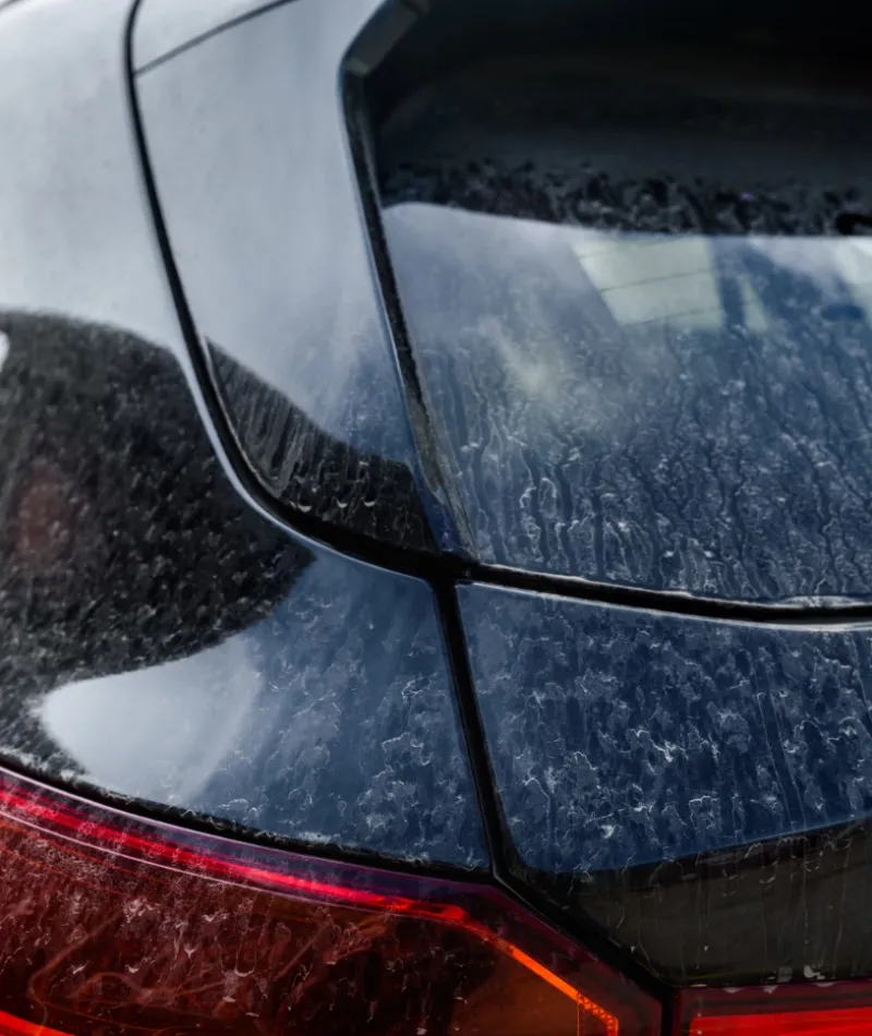 Comparison of a car's rear window before and after cleaning, highlighting dirt removal and clarity improvement.