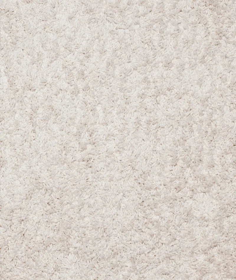 Close-up of soft, fluffy light beige carpet fibers with a textured, plush surface.