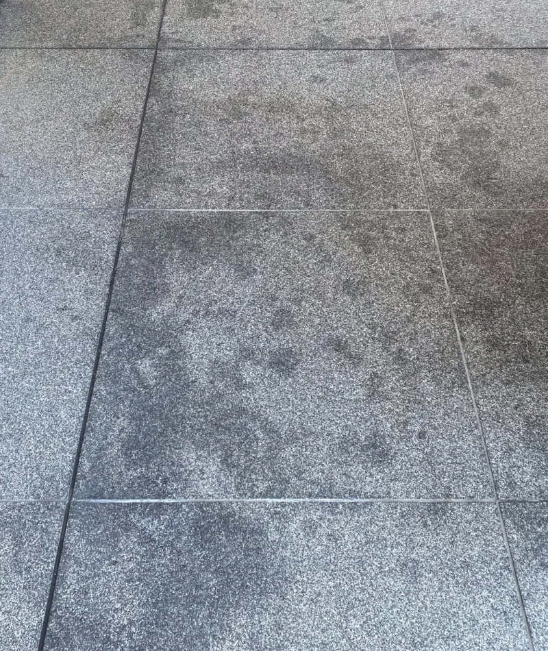 Close-up of textured gray stone tiles arranged in a grid pattern with visible grout lines