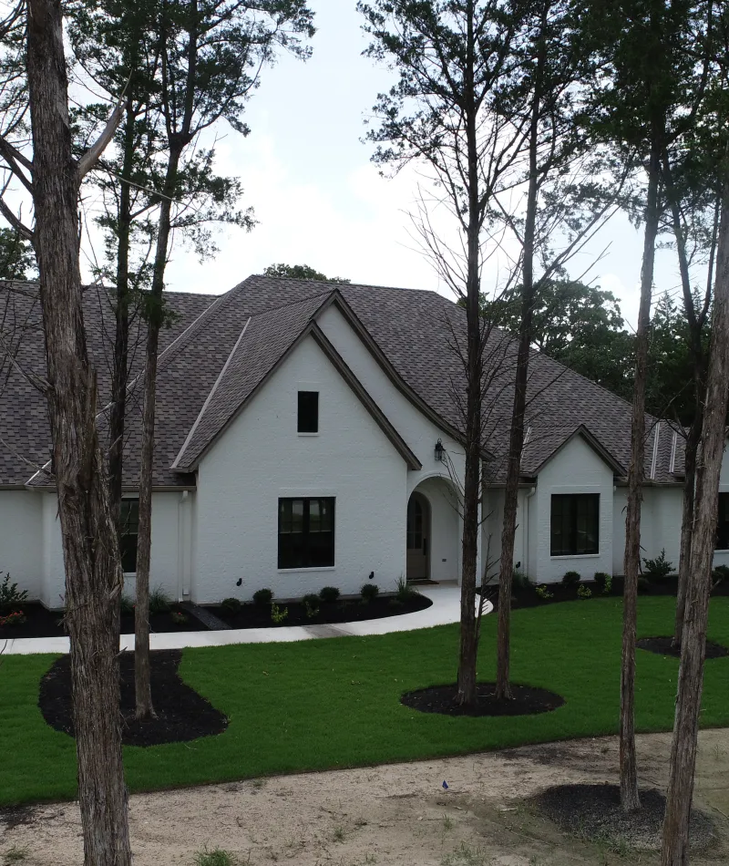 a white house with trees in front of it