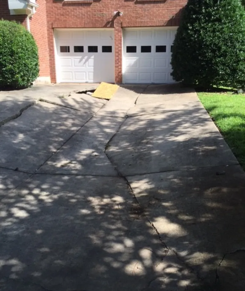 a driveway with a house in the background