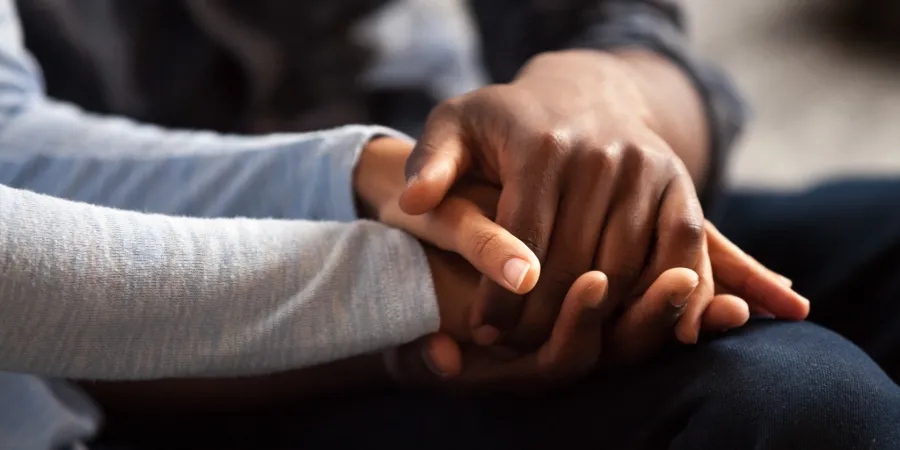 a close-up of a person holding their hands together