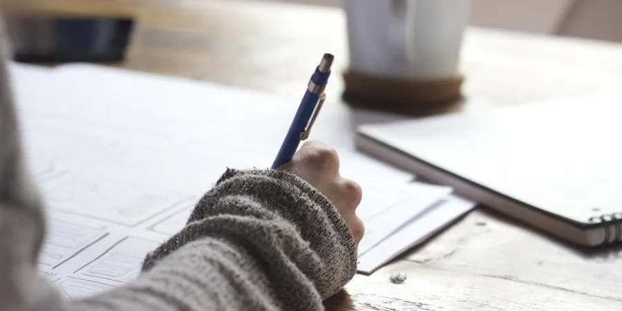 a person writing on a piece of paper