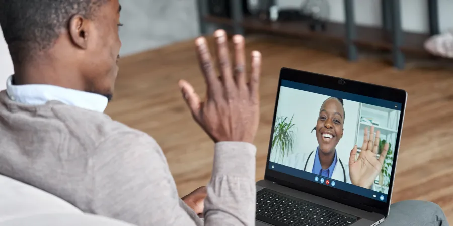a man holding his hand up in front of a laptop