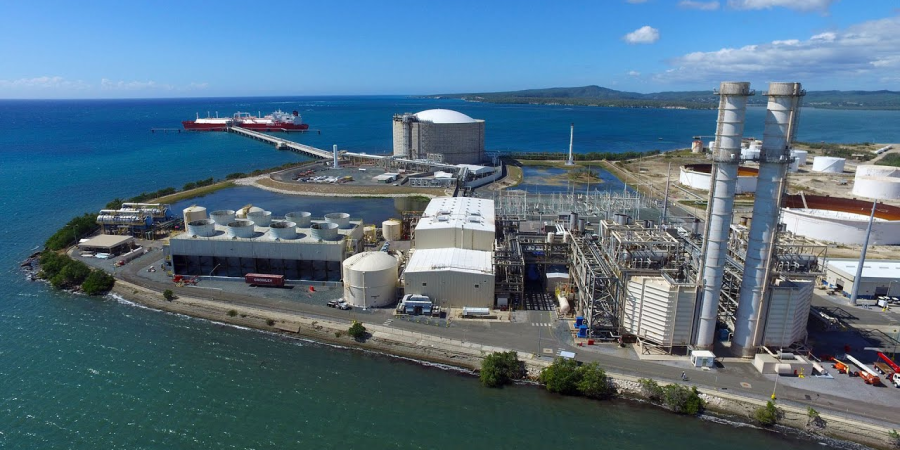 a factory with a body of water in the background