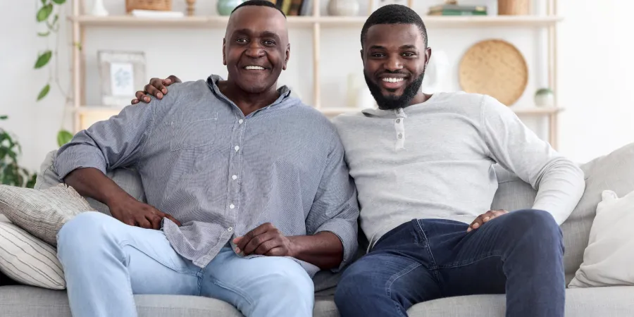 two men sitting on a couch