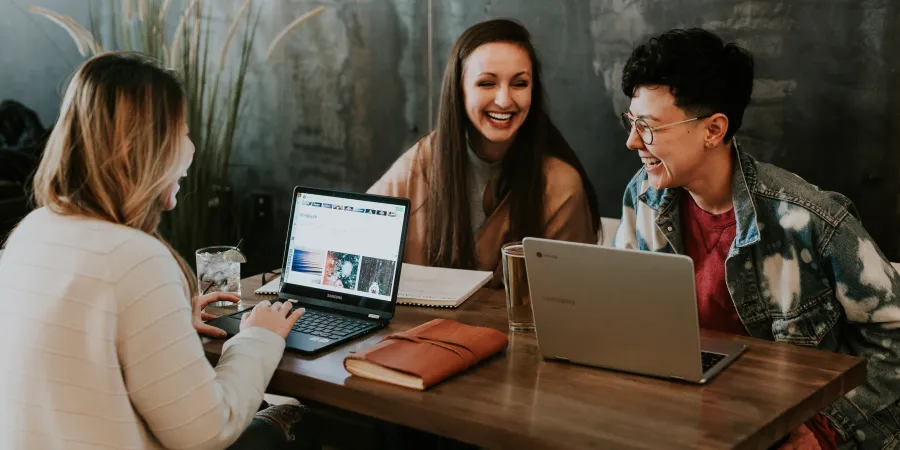 a group of people sitting at a table with a laptop