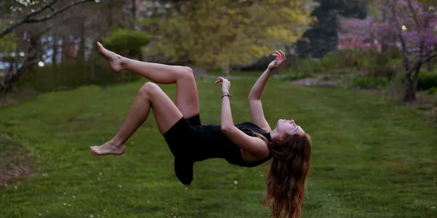 a person standing on a lush green field holding a frisbee