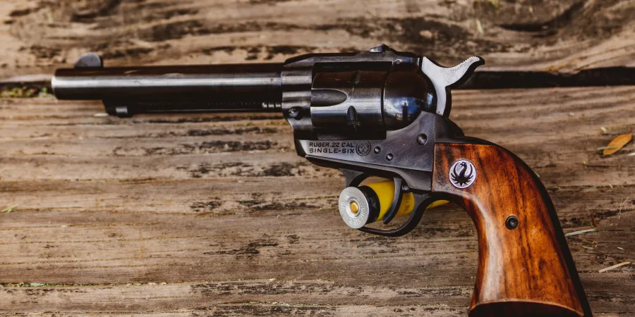 a gun sitting on top of a dirt field