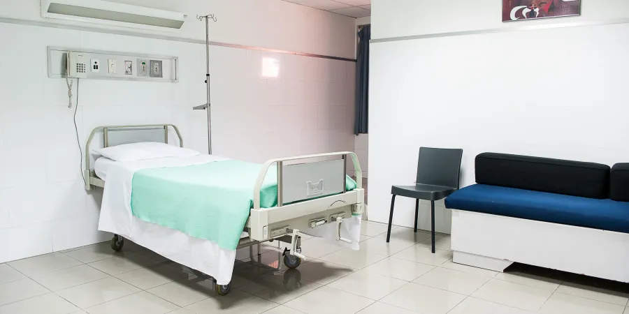 a bedroom with a bed and a chair in a room