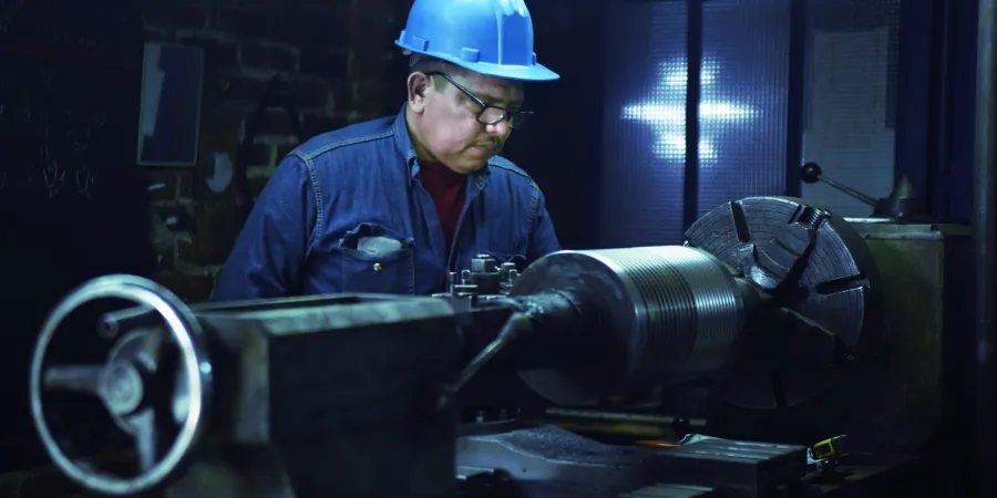a man wearing a hard hat and working on a machine