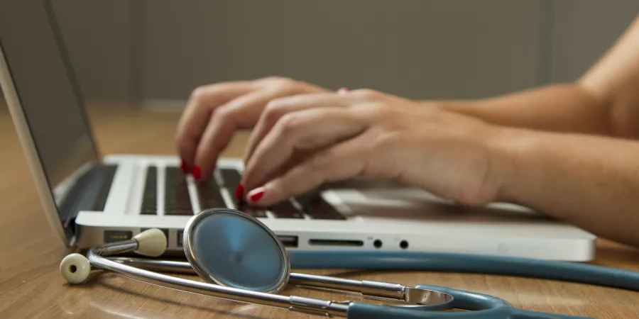 a doctor typing on a computer