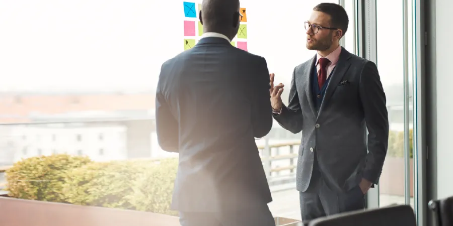 a man in a suit talking to another man in a suit