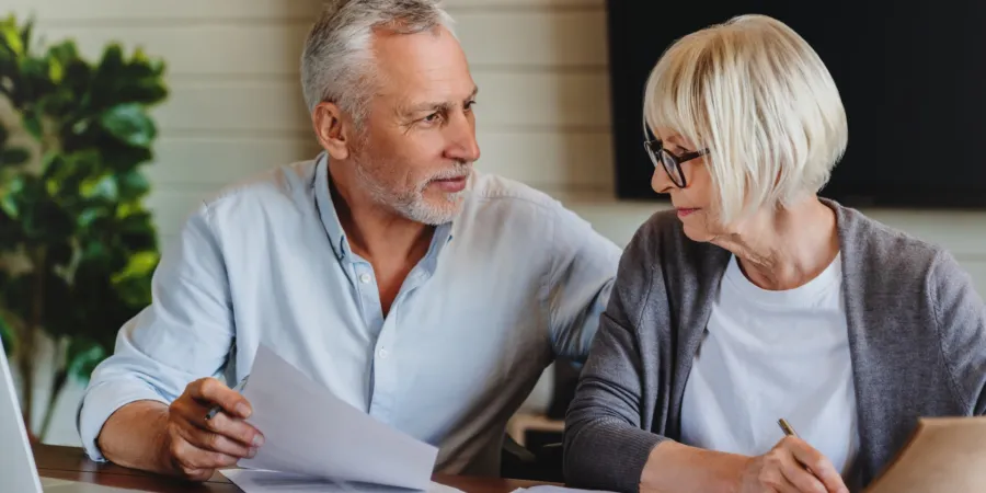 a man and a woman looking at each other with papers