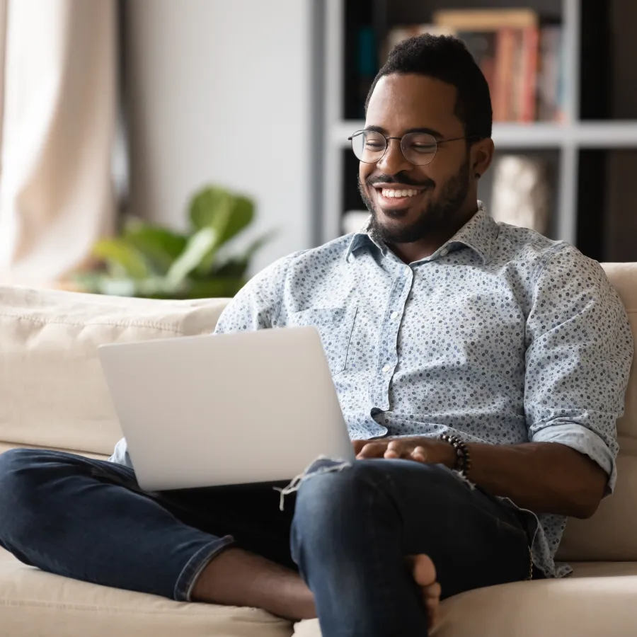 a man sitting on a couch with a laptop