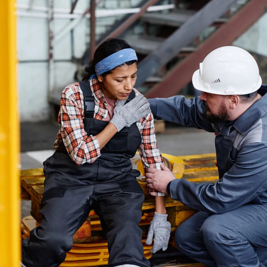 a man and a woman wearing hard hats and sitting on a yellow platform