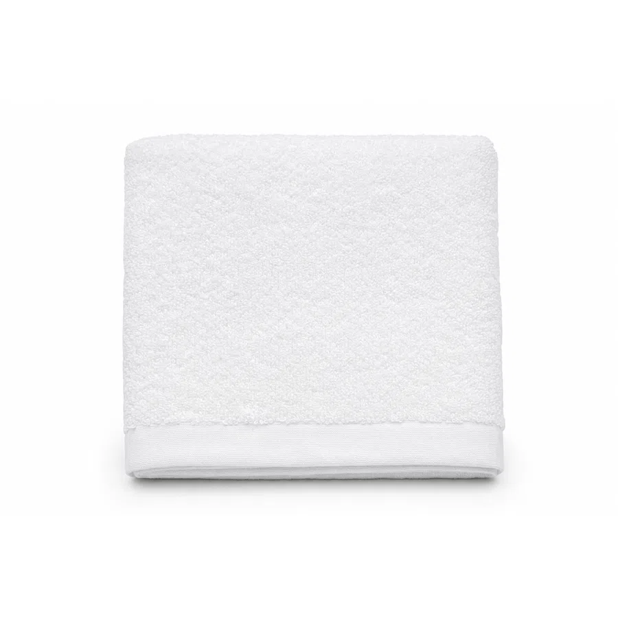 Soft white folded towel with textured fabric and a smooth hem on a white background
