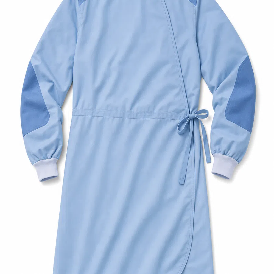 Light blue long-sleeve medical scrub dress with darker elbow patches and side tie closure on white background.