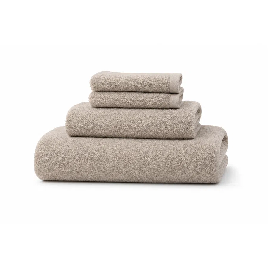 Stack of four beige soft towels in different sizes neatly folded on white background