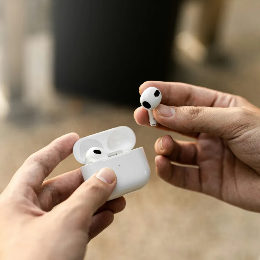 a pair of hands holding white game controllers
