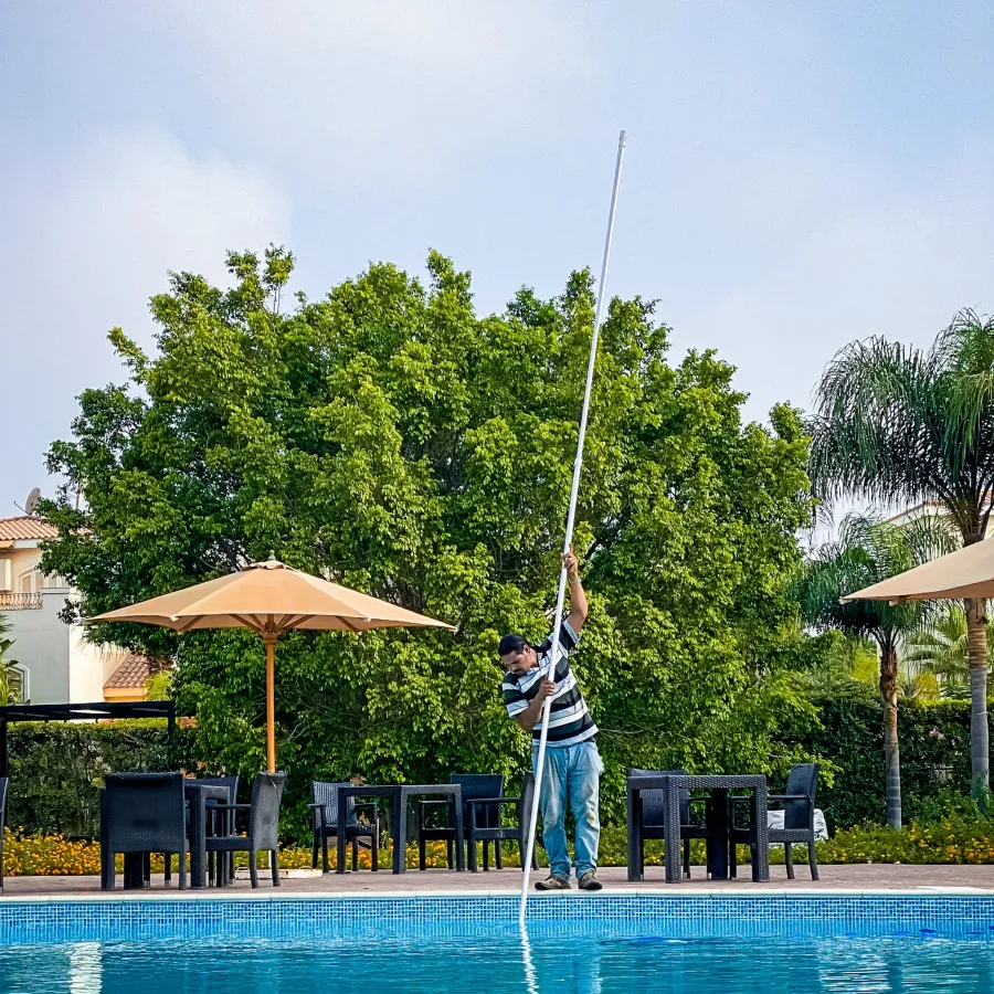 a person holding a fishing pole by a pool