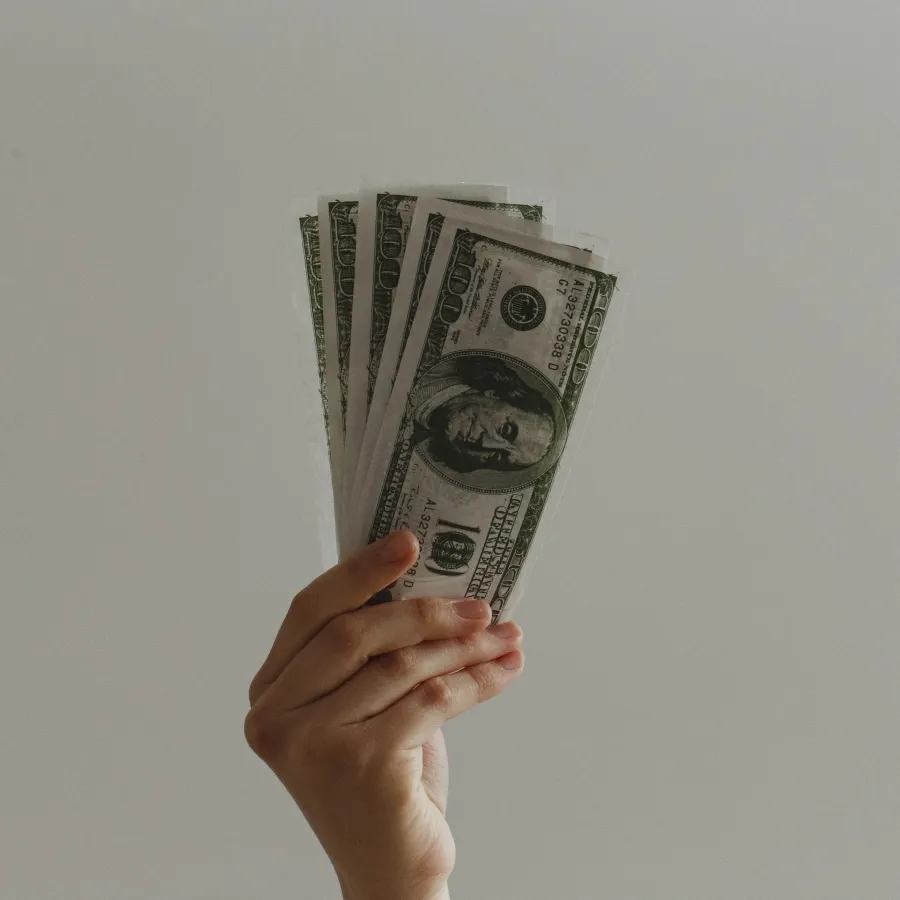 a hand holding a stack of money