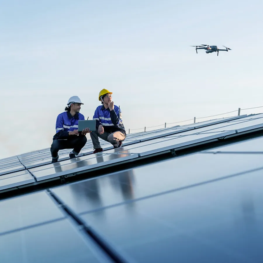 a couple of people sitting on a bridge with a helicopter in the background