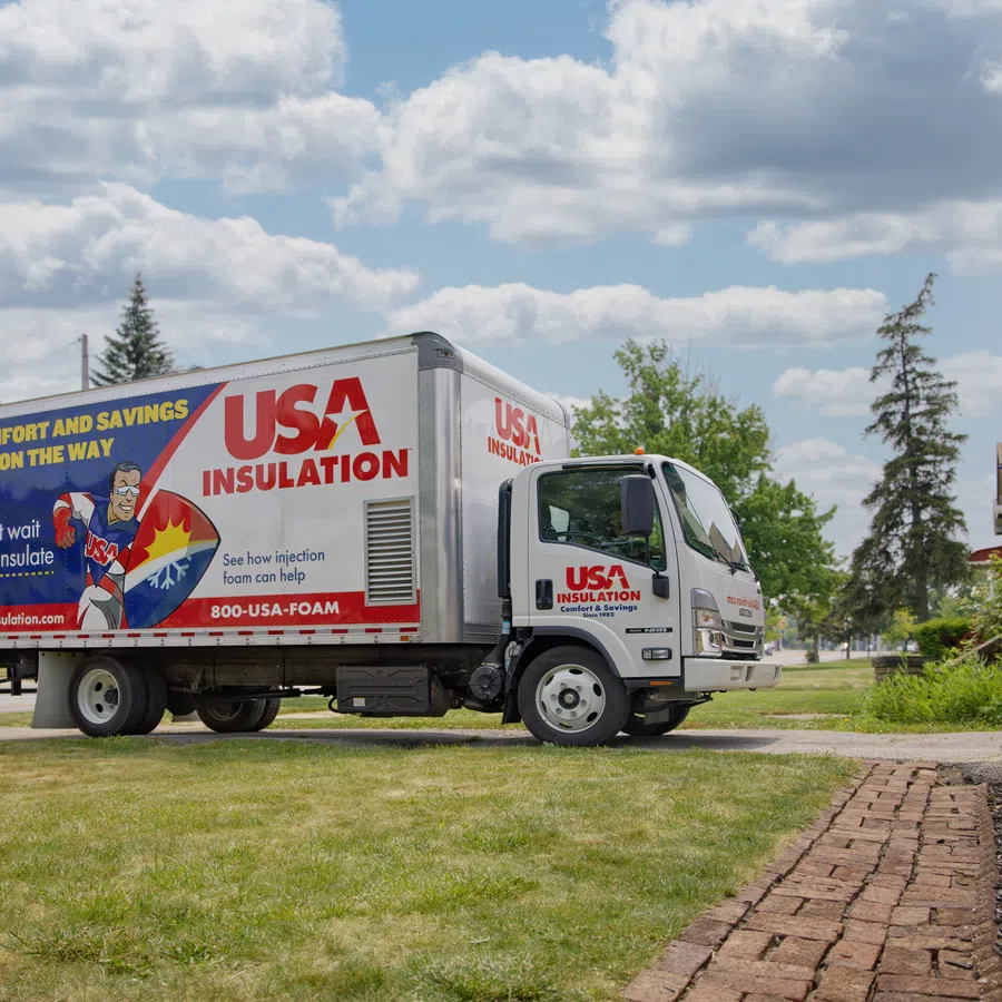 USA Insulation truck parked in residential neighborhood on a sunny day promoting home insulation services.