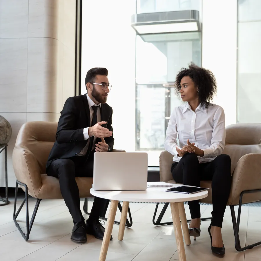 a man and a woman sitting in chairs and talking
