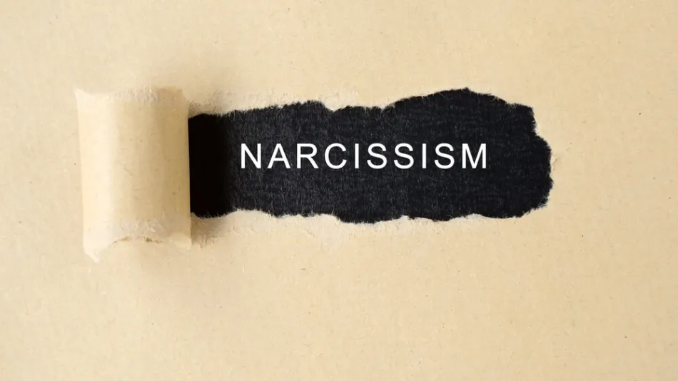 The word narcissism beneath a torn piece of paper